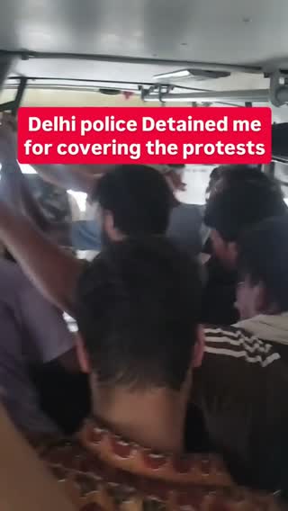 Reporters detained in a police vehicle